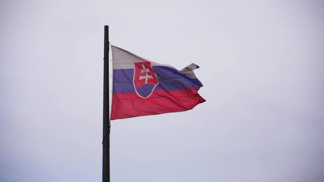 Slovak flag in wind fluttering on flagpole, closeup view of real textile symbol of Slovakia