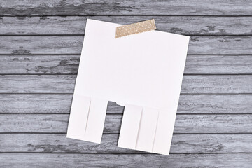 Empty white tear-off stub paper note without text on wooden wall - obrazy, fototapety, plakaty