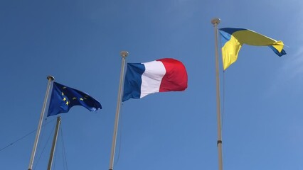 The Ukraine flag and European flag with France flag united in support of the invasion of Ukraine and its joining the European Union. isolated on blue sky background.