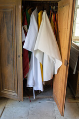 The vestments flutter in an open closet in the sacristy of a country church