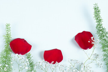 petalos rojos sobre fondo pintado azul laurel con flores pequeñas simulando amapolas