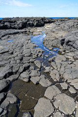 Tide pools on columnar jointed volcanic lava rock in South Point Park, the southernmost point of the United States on the Big Island of Hawaii in the Pacific Ocean