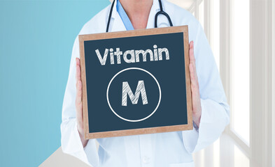 Vitamin M - Doctor shows information on blackboard.Doctor holding chalkboard with text.