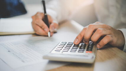 close up hands of accountant calculating tax refund using calculator