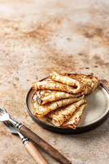 Crepes in brown plate with two rustic forks. Copy space