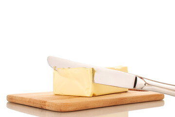 One piece of delicious butter with a metal knife on a wooden cutting board, close-up, isolated on a white background.