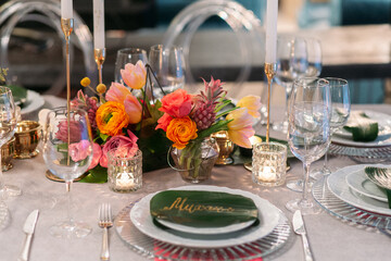 Wedding banquet. Table setting. Banquet tables are decorated with compositions of yellow flowers and protea, ranunculus on the tables are plates with napkins, glasses, candles and cutlery