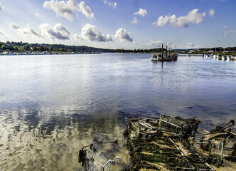 The view along the North bank of the River Medway, in Rochester/Strood. Various boats are moored, but the calm is contrasted with the collection of abandoned shopping trollies, covered in seaweed.