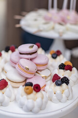 Pink french macaroons on plates. Dessert table with a macaroons composition. Candy bar