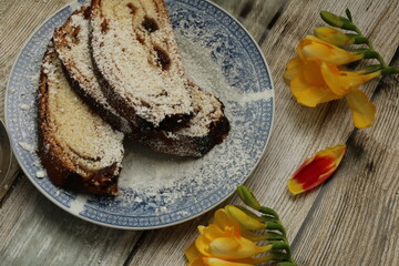 Delicious and tasty backed cake  decorated with Yellow freesias. slices cake in a plate 