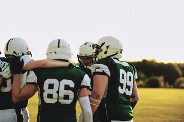 American football players in a huddle during practice