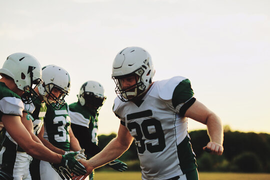 Football players shaking hands on a sports field