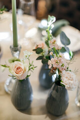 Banquet table is decorated with plates, cutlery, glasses, candles and flower arrangements. Wedding decor