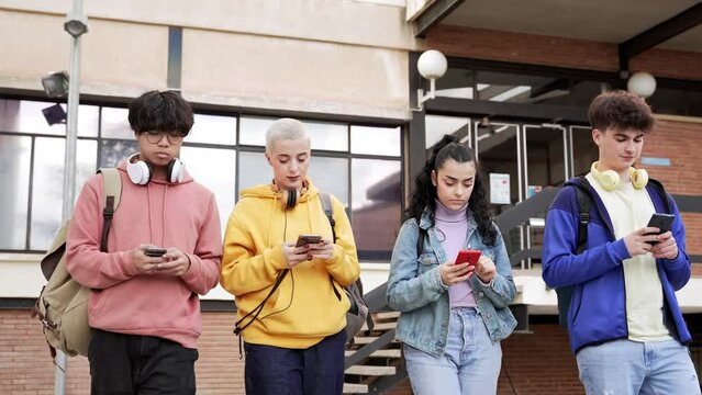 Young college students addicted to internet app, walking while typing on the smartphones - Youth using cellphones and social media 