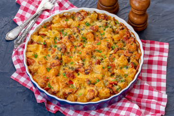 Potato casserole with sausages, onion, tomato and cheese. Baking dish with tasty potato casserole...