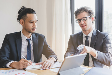 Business professional people group, team of young asian, caucasian working and communicating, analyzing data, discussing, using calculator calculate explain cost about new project with colleagues.