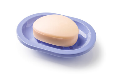Soap on a soap dish isolated on a white background. Oval shaped beige soap bar in a violet blue...
