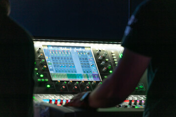 People working with lights and sound control equipment at the concert