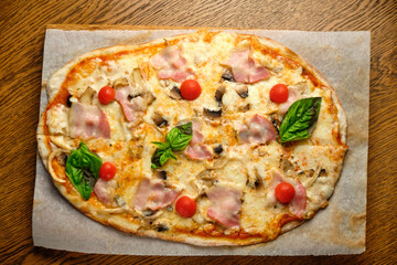 Pizza with bacon and ham and tomatoes