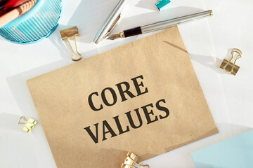 Crafted envelope with text Core Values on office table and tools around.