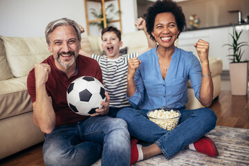 Excited family football fans watching sport tv game celebrating goal together