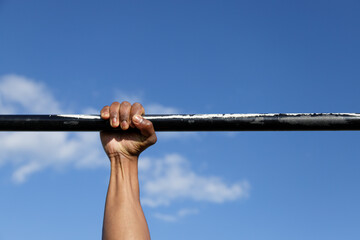 Calisthenics. Hands on bar. Outdoor training and working out.
