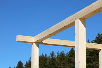 Wooden beams of construction structure, on background of blue sky 