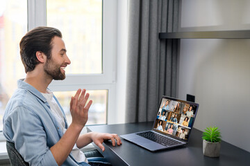 Caucasian man using laptop for video connection with friends. Man talking with young people on the...