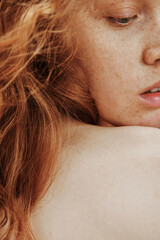Close-up portrait of young woman with freckles on her face and red hair posing with shirtless back - obrazy, fototapety, plakaty