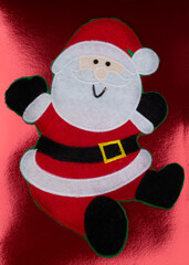 Funny santa claus made of cloth on a red background.