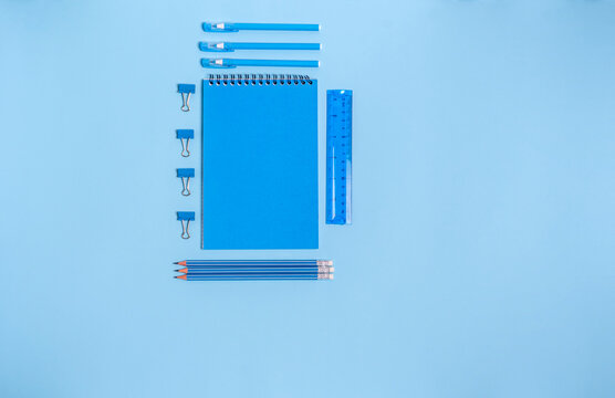Exercise book with items for school on a blue background