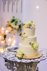 White wedding cake with flowers on table