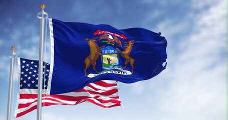 The Michigan state flag waving along with the national flag of the United States of America - Powered by Adobe