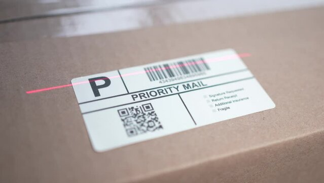 Scanning a Priority Mail Shipping Label on a Cardboard Box