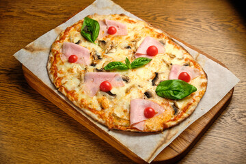 Pizza with bacon and ham and tomatoes