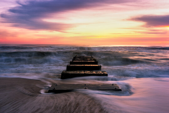 Summer sunrise over ocean outfall pipes along the Outer Banks of North Carolina
