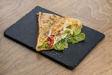 Pancake with chiken on a black tray