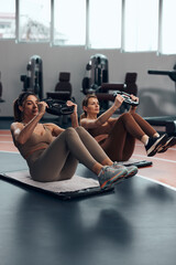 Pretty women working out in a gym. Adult ladies with beautiful shaped bodies.