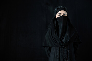 portrait mysterious muslim woman on black background