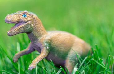 some dinosaurs toys in the green grass. happy dinosaur day, may 15 and june 1. fascinating dinosaur fantasies. spring summer outside, public park, kids having fun