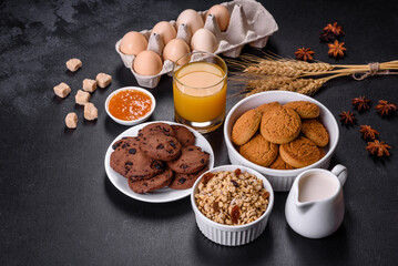 Delicious nutritious healthy breakfast with granola, eggs, oat cookies, milk and jam