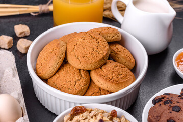 Delicious nutritious healthy breakfast with granola, eggs, oat cookies, milk and jam