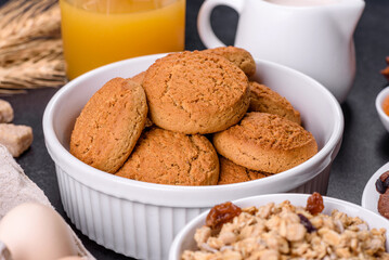 Delicious nutritious healthy breakfast with granola, eggs, oat cookies, milk and jam