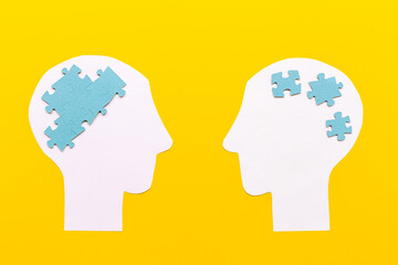 Communication. Chaos and peace in brain - two paper human heads with puzzles