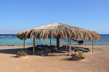 Fototapeta na wymiar A straw canopy on the seashore. Sinai peninsula, Egypt.