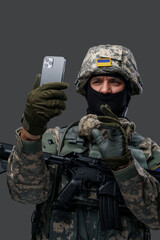 Shot of confused serviceman from ukraine with smartphone dressed in camouflage uniform. Information war.