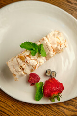 Cake with meringue roll with cream and raspberries