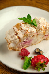 Cake with meringue roll with cream and raspberries