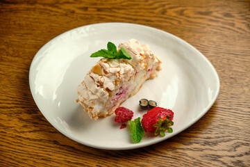 Cake with meringue roll with cream and raspberries