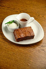 Chocolate cakes on a wooden table with ice cream and mint leaf on top
